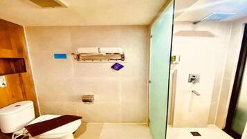 Un baño moderno con inodoro, cabina de ducha de vidrio y toallero.