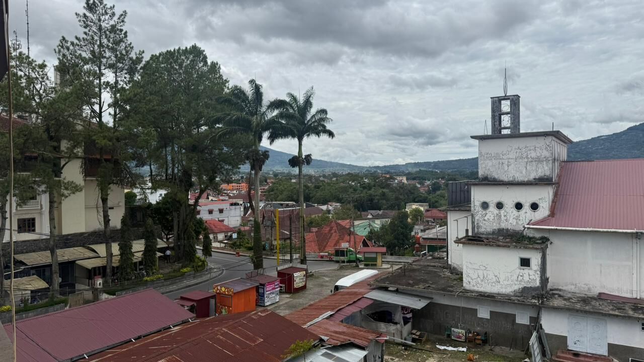 A town with buildings, a church, and a hill in the background.