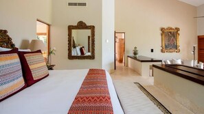 Une chambre d’hôtel avec un grand lit, un bureau, un miroir et un tableau au mur.