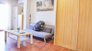 Una sala de estar moderna con un sofá, un aparador de madera y un cuadro en la pared.