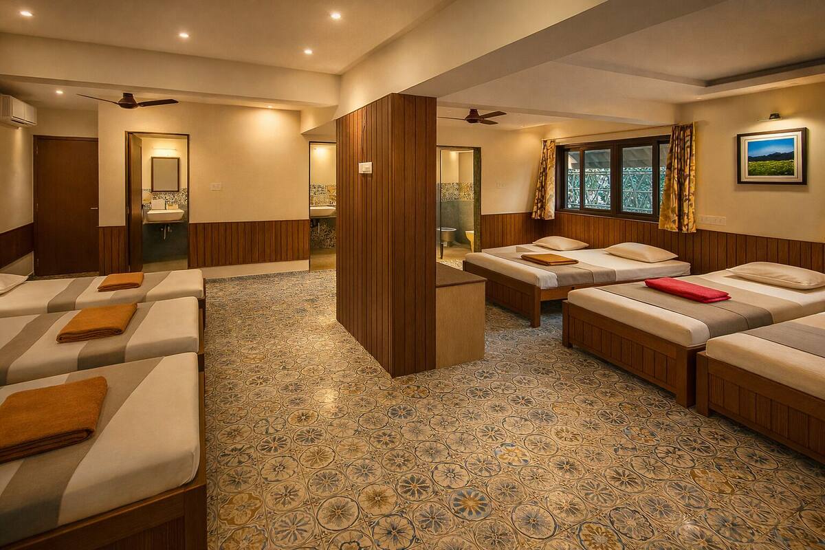A hotel room with four beds, a bathroom, a window with curtains, and a ceiling fan.