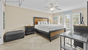 A bedroom with a bed, bedside table, lamp, and a bench. - Ocean Club Villa D-206 | Your Coastal Paradise Awaits! (Biloxi)