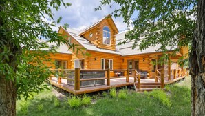 A wooden cabin with a porch, a window, and a door.