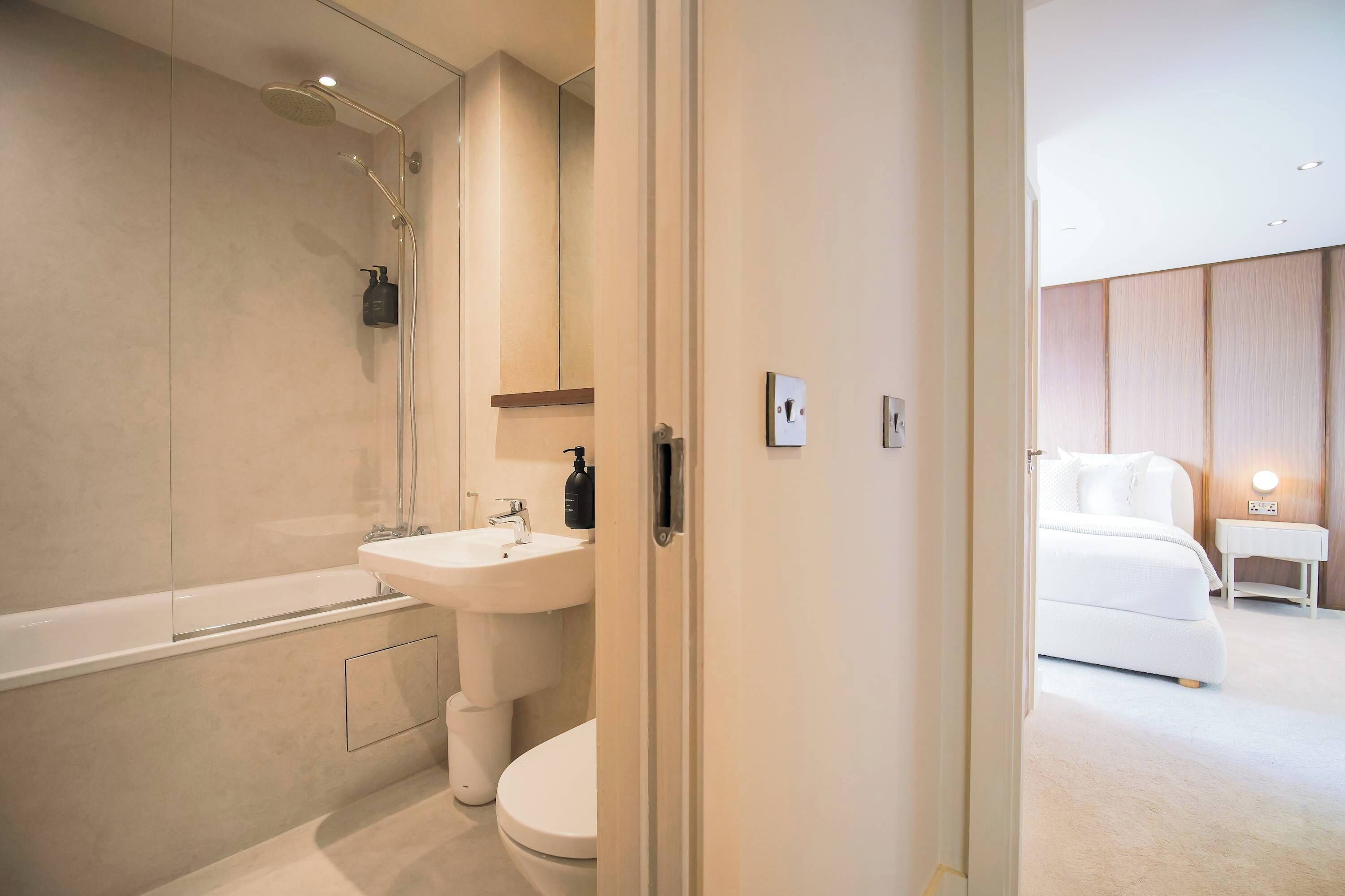 A modern bathroom with a bathtub, sink, and toilet.