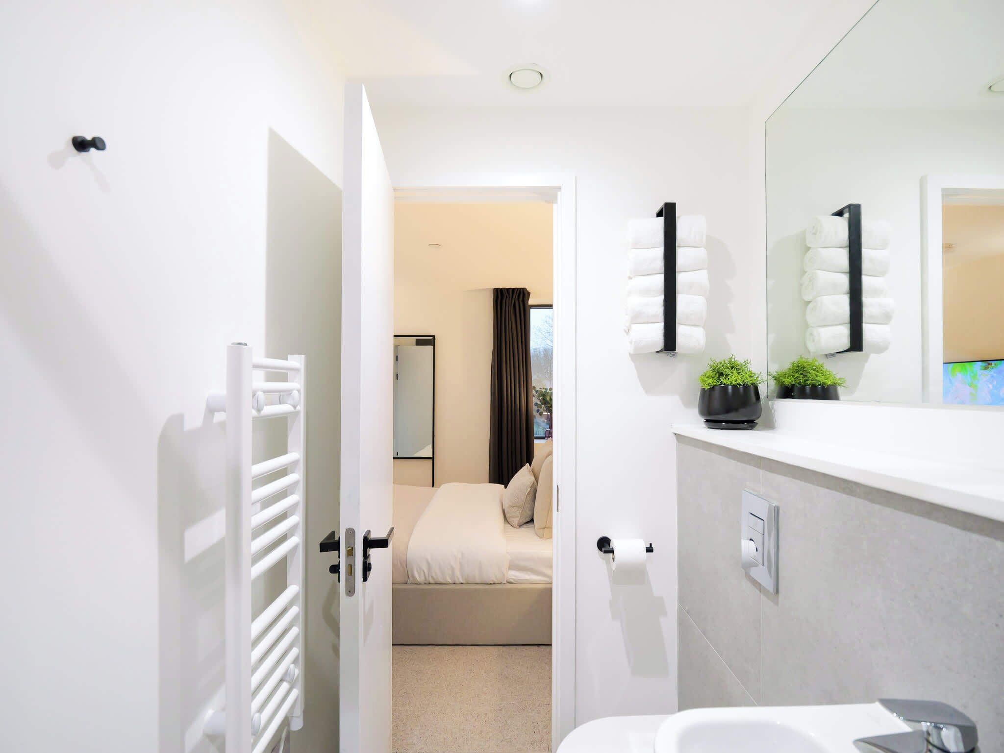 Un bagno moderno con un lavandino bianco, uno specchio e un water.