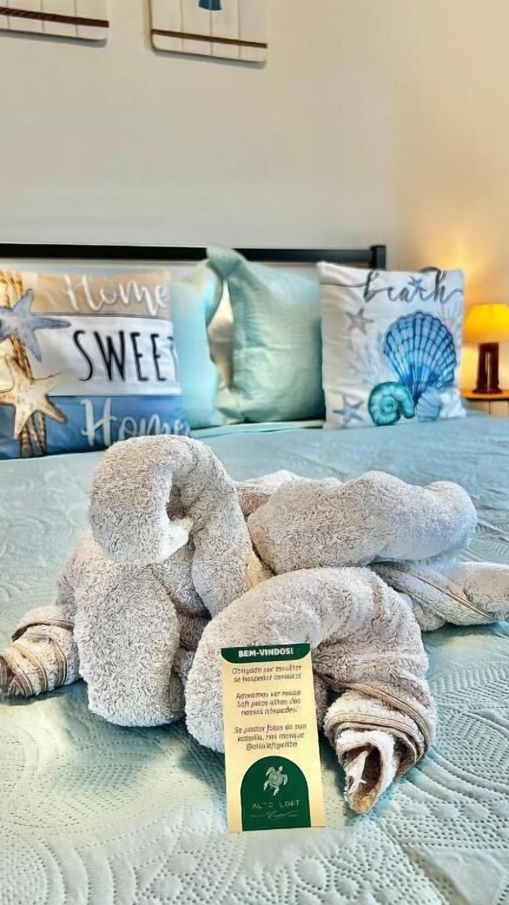 A neatly folded towel with a tag on a bed.
