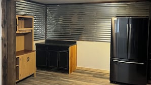 A compact kitchen with a black refrigerator, wooden cabinets, and a built-in microwave. - Tobacco Riverwalk Condo - Eureka, MT (Eureka)
