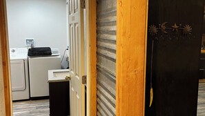 A narrow hallway leading to a kitchen with a washing machine, a sink, and a door with a decorative metal hook. - Tobacco Riverwalk Condo - Eureka, MT (Eureka)