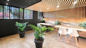 A modern interior with a wooden ceiling, large windows, and potted plants. - Oceana Suites Toesca (Santiago)