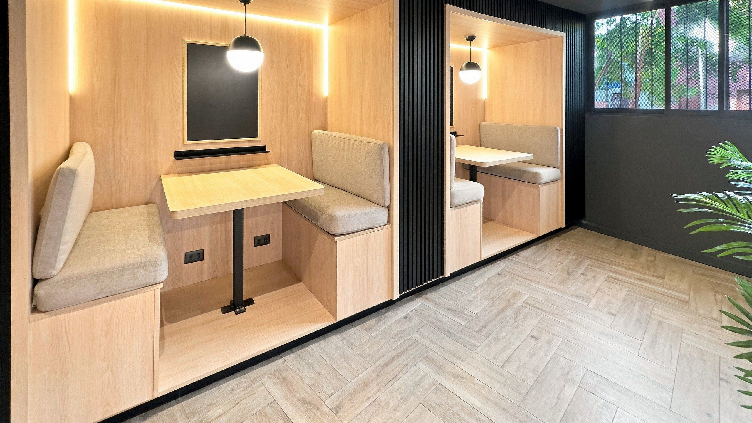 Un intérieur moderne avec des murs en bois, un parquet en point de Hongrie et des espaces de détente avec des tables et des chaises.