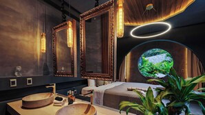 Ein modernes Badezimmer mit zwei runden Waschbecken, einem großen Spiegel und einem Rundfenster mit Blick auf Grünflächen.
