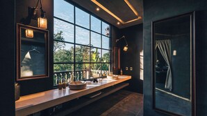 Ein modernes Badezimmer mit großem Fenster, zwei Waschbecken und einem Spiegel.