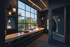 Ein modernes Badezimmer mit großem Fenster, zwei Waschbecken und einem Spiegel.