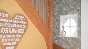 Eine Holztreppe mit einem herzförmigen Schild an der Wand.