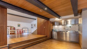 Une cuisine moderne dotée d’appareils électroménagers en acier inoxydable, d’un plancher en bois et d’un escalier menant à l’étage supérieur.