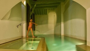 A room with a glass floor, a person in a swimsuit, and a green ceiling. - Donna Lavinia with indoor pool (Città della Pieve)