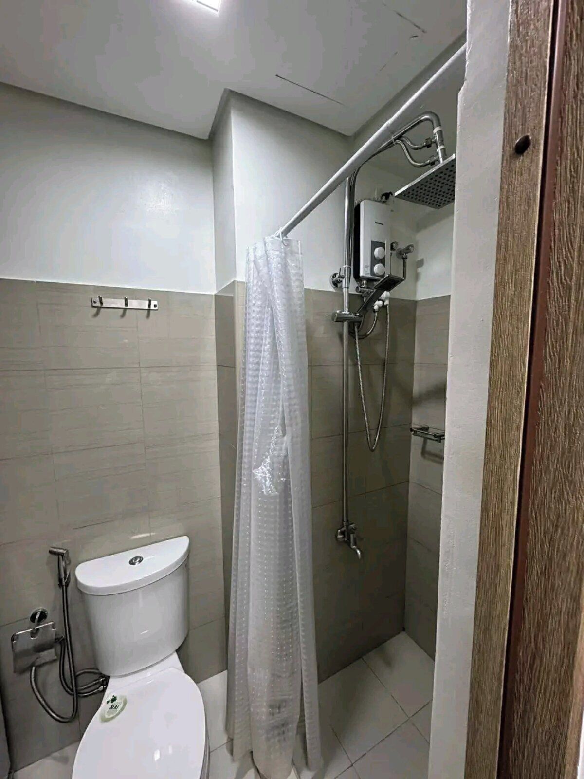 Ein kleines, modernes Badezimmer mit Toilette, Dusche und einer Glasabtrennung.