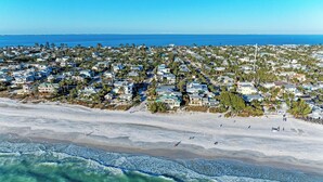 Vista aerea di una zona residenziale costiera con case, una spiaggia e l'oceano.