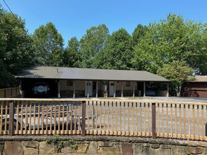 Un motel doté d’un parking couvert et d’un mur de pierre en premier plan.