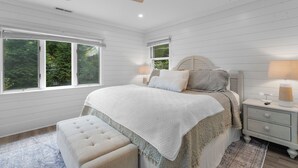 A bedroom with a large bed, a nightstand, a ceiling fan, and large windows. - Grace Cottage, St Michaels Walk to everything! (Saint Michaels)