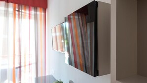 A modern interior with a large, flat-screen TV mounted on a white wall. - Zenit Hotel (Giulianova)