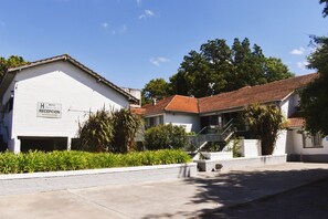A hotel with a reception area, a covered outdoor seating area, and a parking lot. - Hotel Agustin Garcia (Tigre)