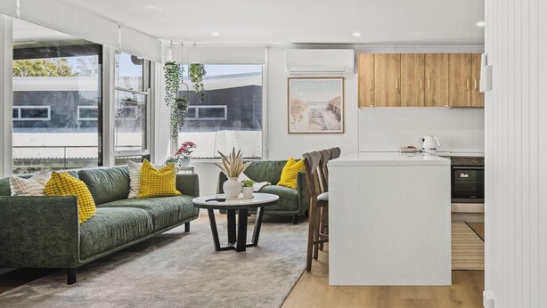 Ein modernes Wohnzimmer mit Sofa, Couchtisch und Blick ins Freie.