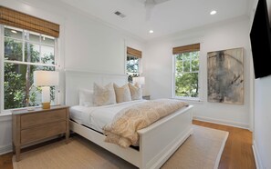 A bedroom with a bed, nightstands, a window with a view, and a painting on the wall. - Pelican & Palm - WaterColor Home & Golf Cart! (Santa Rosa Beach)