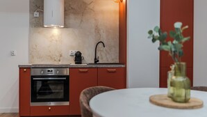 Eine moderne Küche mit Einbauofen, Kaffeemaschine und Spüle.