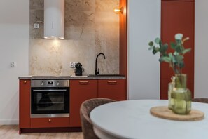A modern kitchen with a built-in oven, a coffee maker, and a sink. - Złota 7 Apartment (Warszawa)