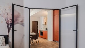 Ein modernes Interieur mit Essbereich, Küche und einer teilweise offenen Raumtrennung.
