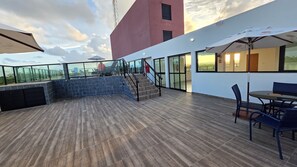 Een dakterras met houten vloer, een trap en zitplaatsen buiten.