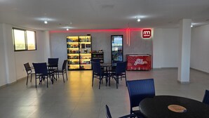 A modern interior with a dining area, a snack bar, and a Redmart sign. - Studio piscina privativa 10 by La Playa (Ipojuca)