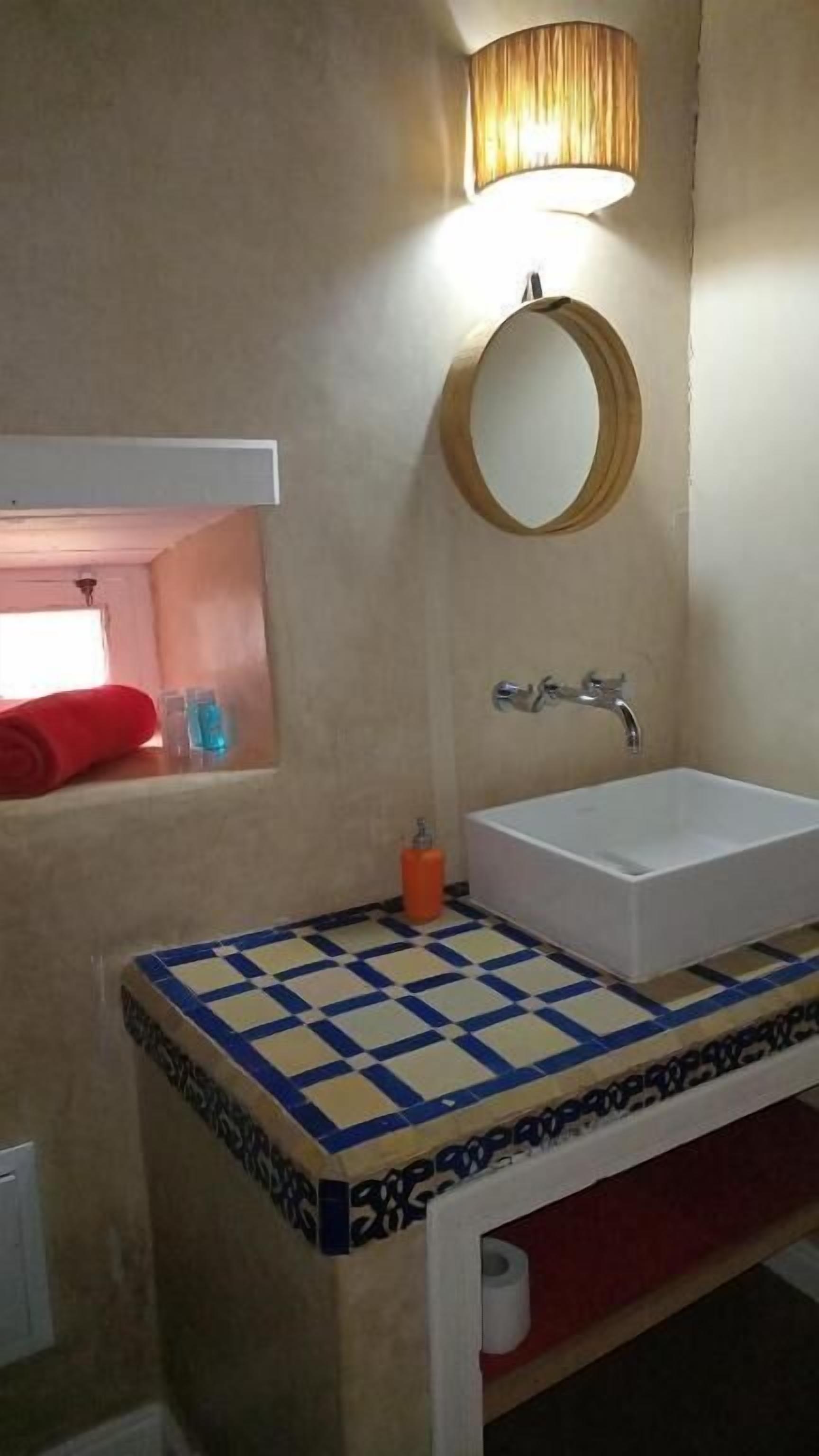 Une salle de bain équipée d’un lavabo, d’un miroir et d’un porte-serviettes.