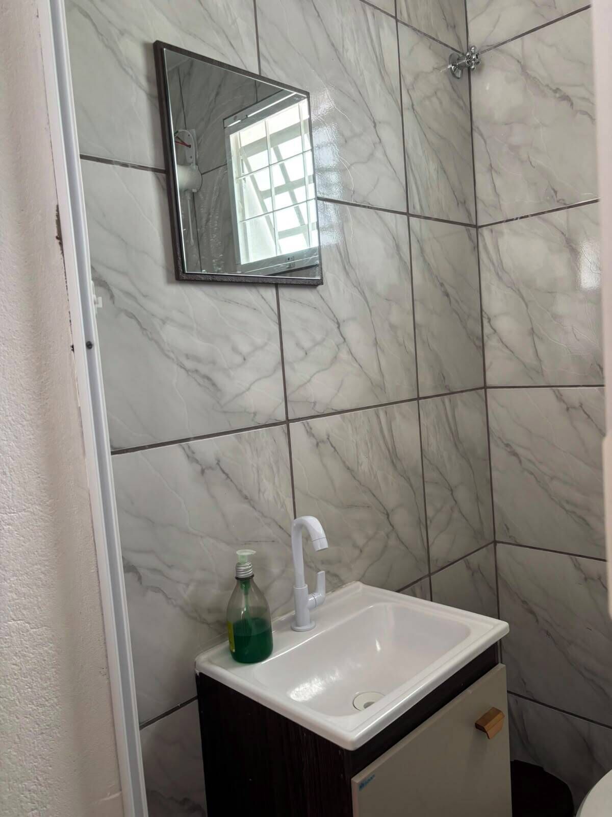 A bathroom with a white sink, a mirror, and a shower.