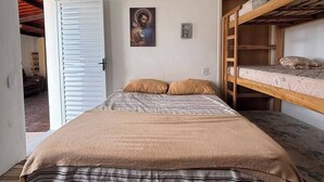 A bedroom with a bunk bed, a single bed with a striped bedspread, a door leading to another room, and a framed picture on the wall. - Pousada Recanto Alto Da Boa Vista (Cachoeira Paulista)