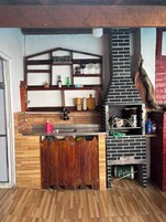 Una cocina con horno de ladrillo, repisas de madera y mostrador de madera.