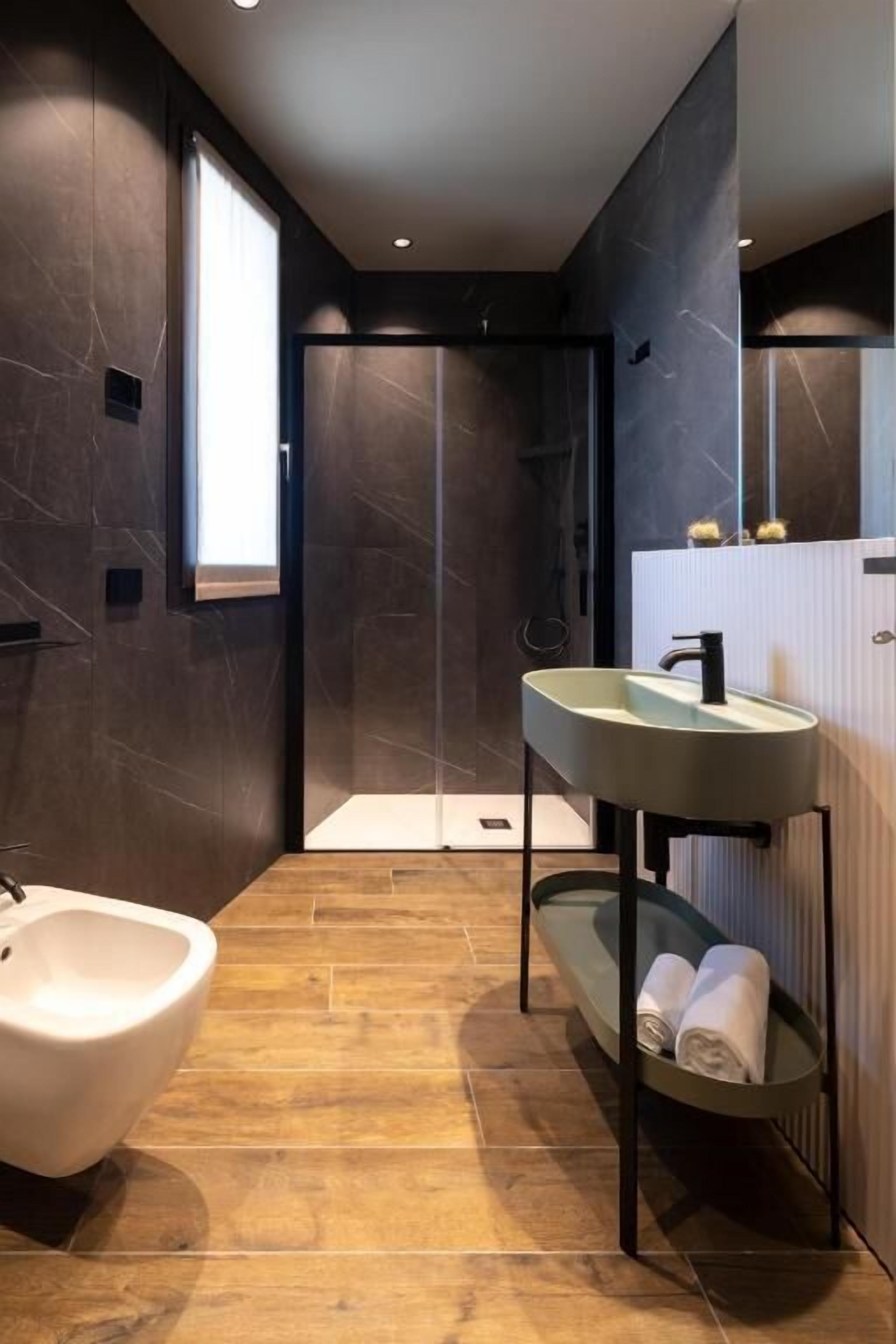 Een moderne badkamer met een vrijstaand bad, een wastafelmeubel met een wastafel en een douchehoek.