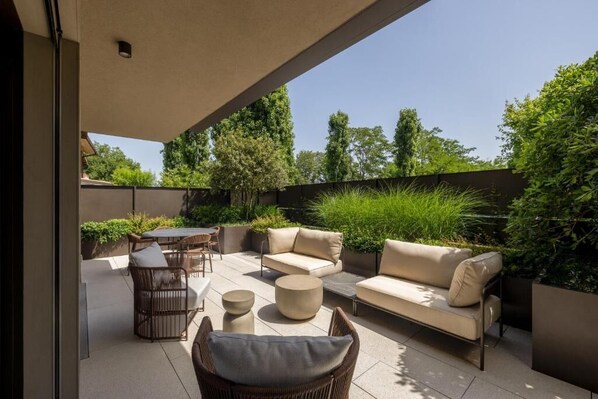 An outdoor patio area with a sofa, chairs, and a table. - Stemor srl (Desenzano del Garda)