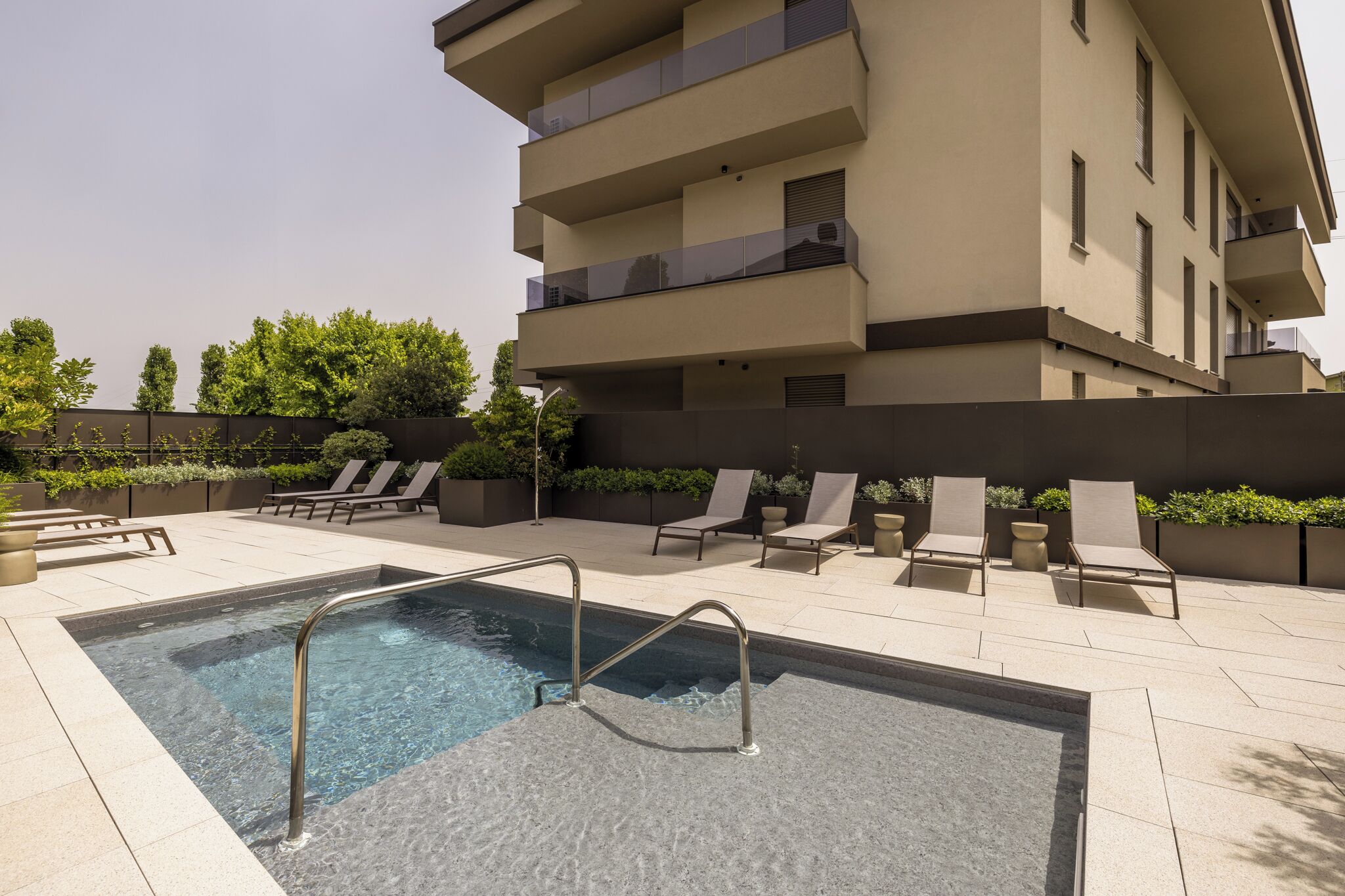 A modern outdoor pool area with lounge chairs and a clear pool.