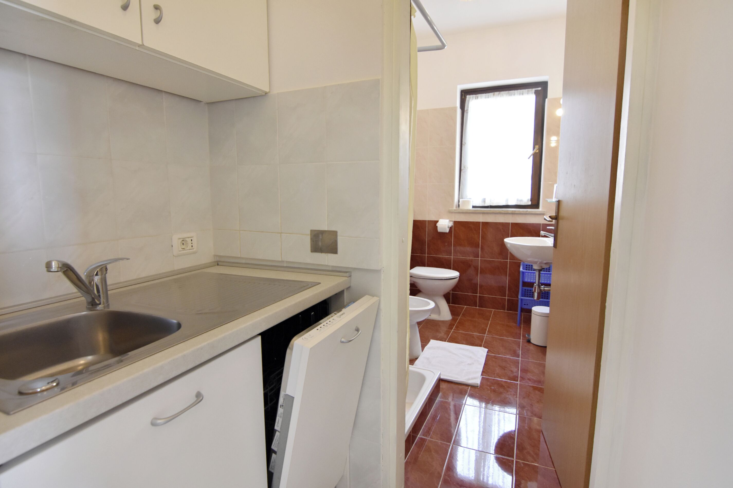 Una cocina con lavabo, armarios y lavavajillas.