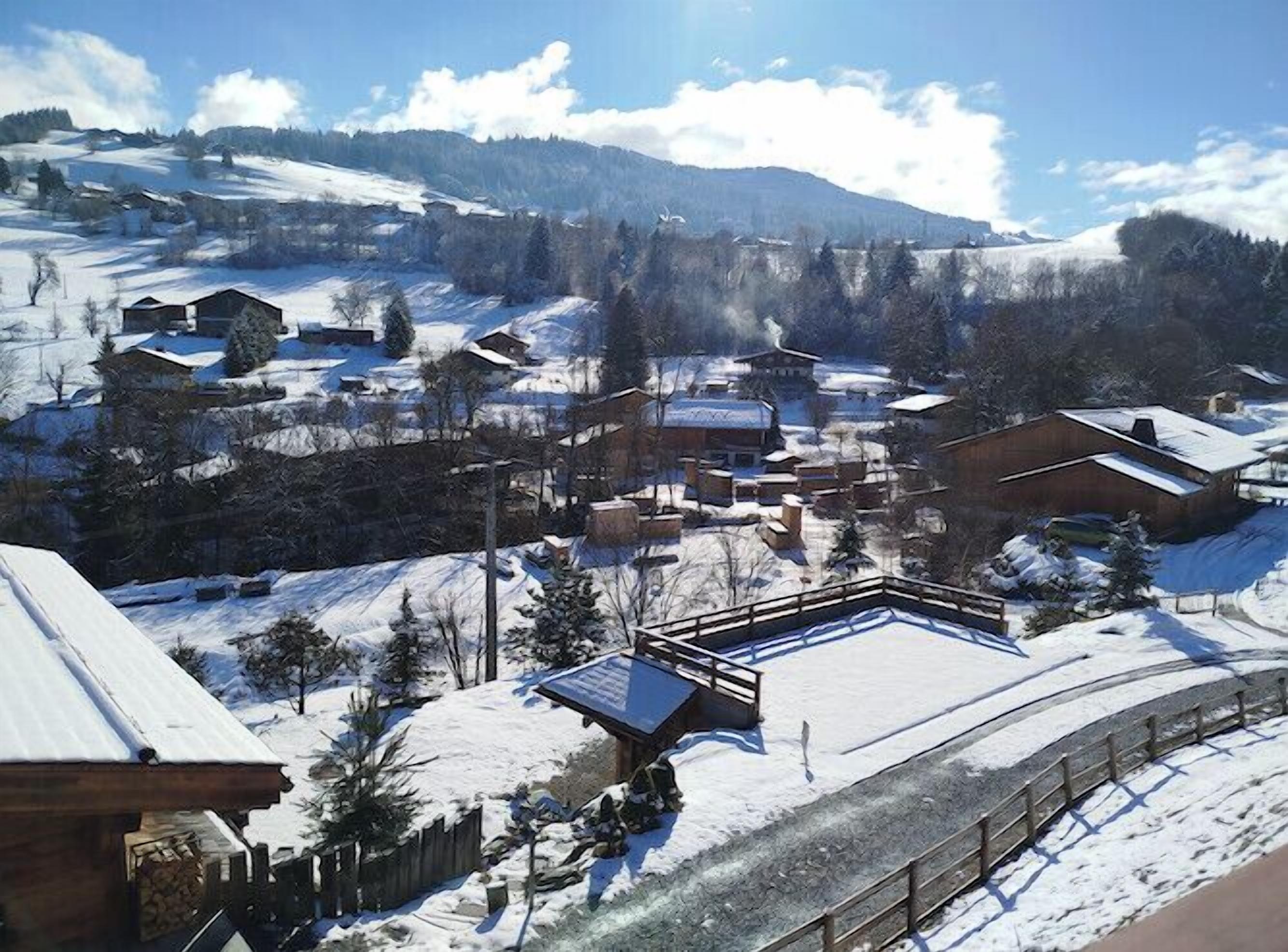 A snow-covered village with wooden buildings and a clear sky.