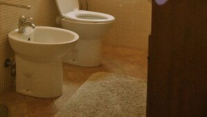 Ein Badezimmer mit Toilette, Bidet und Waschbecken.