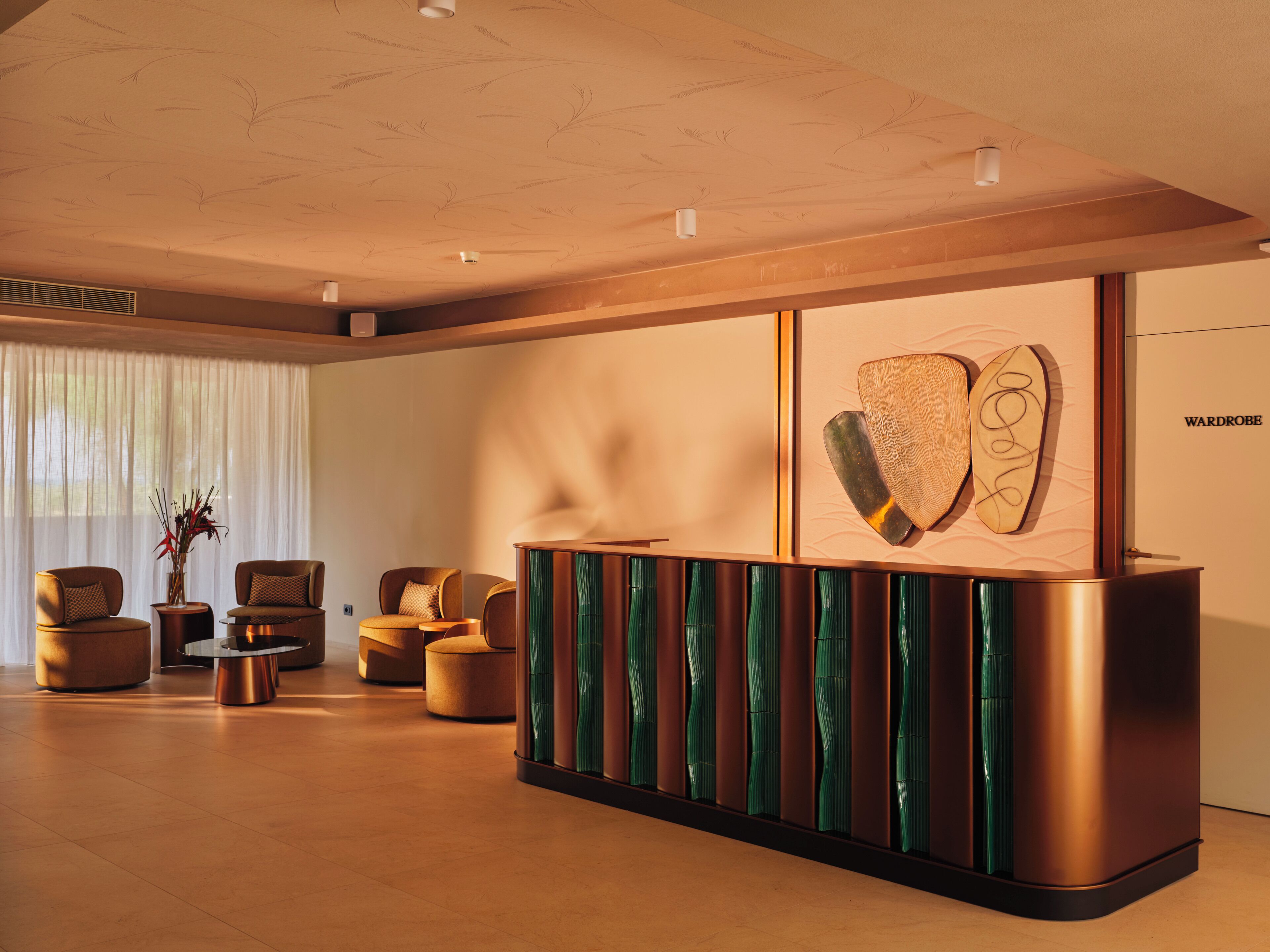 Un espace d’accueil moderne, doté d’un comptoir de réception en bois, de sièges confortables et d’une grande fenêtre agrémentée de rideaux légers.