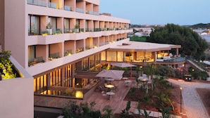 Un hôtel à plusieurs étages doté de balcons, d’un espace extérieur aménagé et offrant une vue sur le paysage.