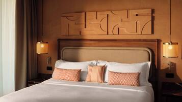 A hotel room with a large bed, two bedside lamps, and a decorative wall panel above the bed.