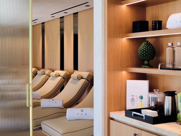 A spa room with massage chairs, a wooden wall, and a counter with amenities. - Icona's Costa Ragusa Resort - New Opening (Scoglitti)
