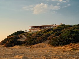Una casa moderna en una colina con cielo despejado.