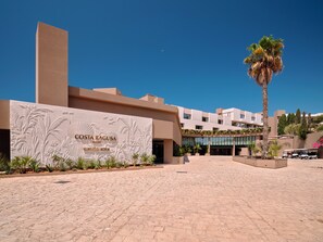 Ein Resort mit auffälligem Eingang, Palmen und blauem Himmel.