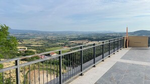 Een balkon met metalen hekwerk met uitzicht op een prachtig landschap.
